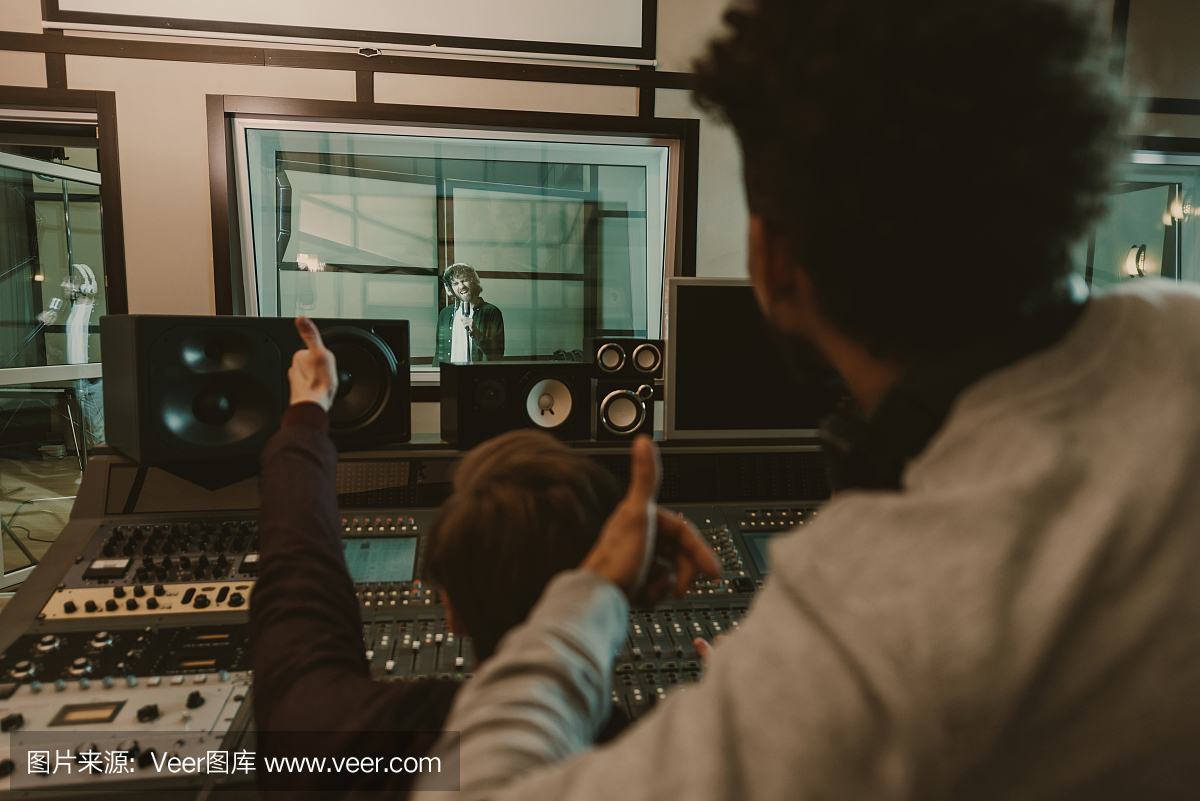 聲音制作人在錄音棚向歌手豎起大拇指